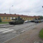 Militärkolonn passerar på Västanväg en tidig sommarmorgon.